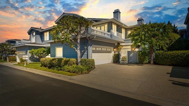 view of front facade with driveway, a balcony, and an attached garage