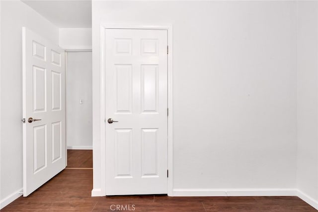 unfurnished bedroom with dark wood finished floors and baseboards