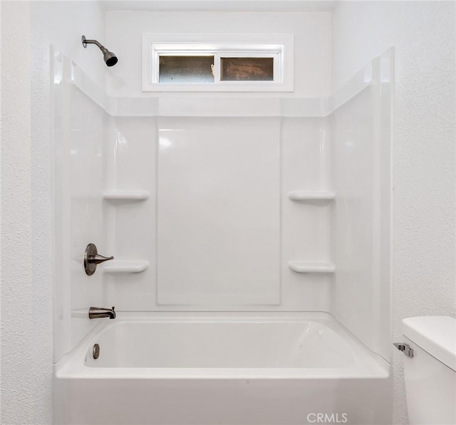 bathroom featuring bathing tub / shower combination and toilet