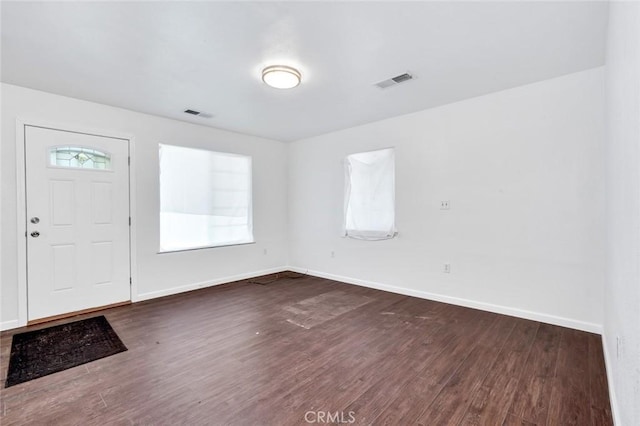 entrance foyer with visible vents, plenty of natural light, baseboards, and dark wood-style flooring