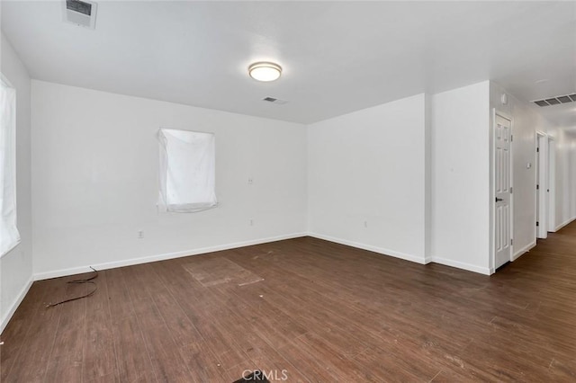 spare room featuring visible vents, baseboards, and wood finished floors