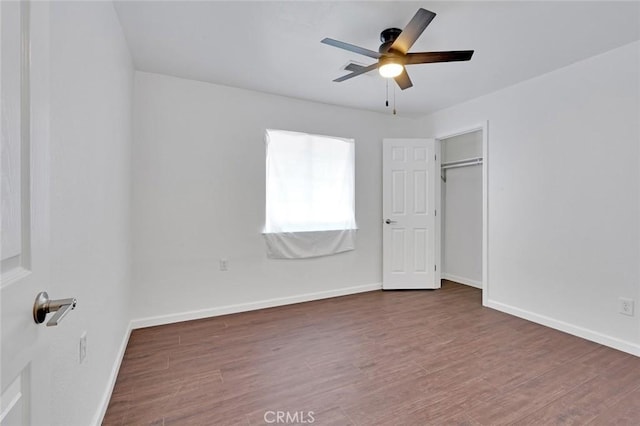 unfurnished bedroom featuring baseboards, wood finished floors, and a ceiling fan