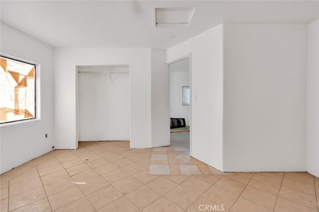 unfurnished bedroom featuring light tile patterned floors and a closet