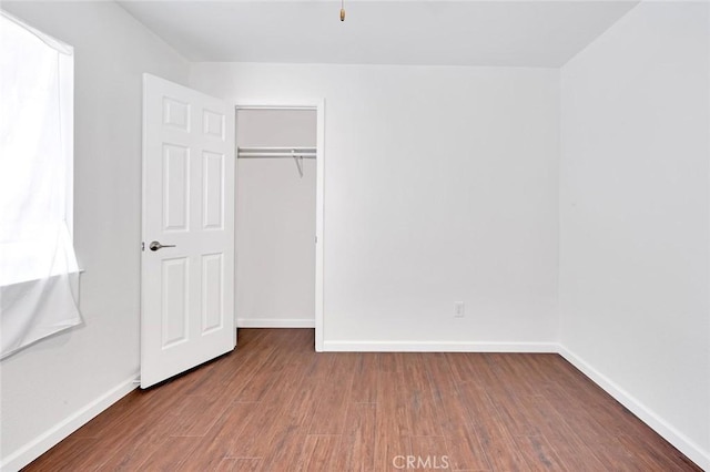 unfurnished bedroom with baseboards and wood finished floors