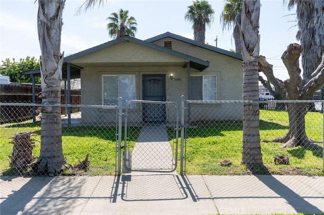 bungalow with stucco siding, a fenced front yard, a front yard, and a gate