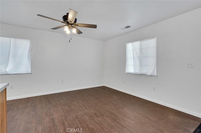 empty room featuring dark wood finished floors and baseboards