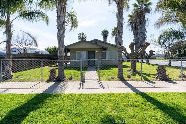 view of front of house featuring a fenced front yard, stucco siding, a front lawn, and a gate