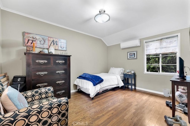 bedroom featuring a wall mounted air conditioner, ornamental molding, wood finished floors, baseboards, and vaulted ceiling