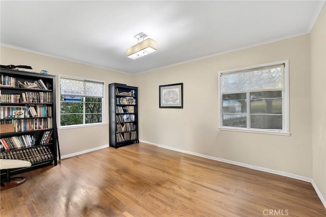 interior space featuring ornamental molding, baseboards, and wood finished floors