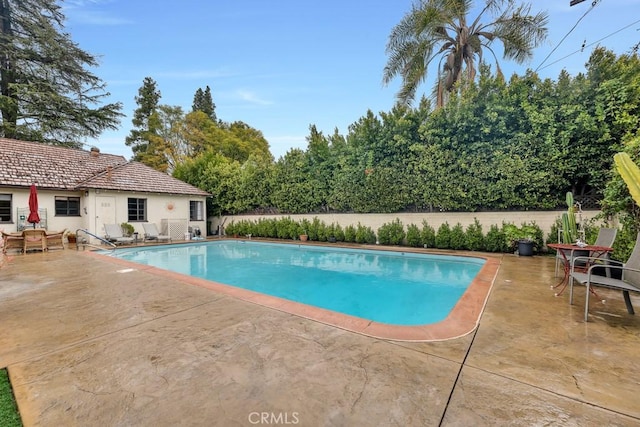 view of swimming pool with a patio area, a fenced in pool, and fence