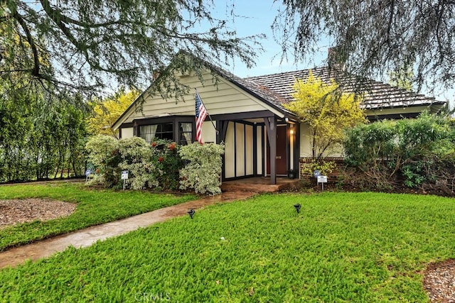 view of front of home featuring a chimney and a front lawn