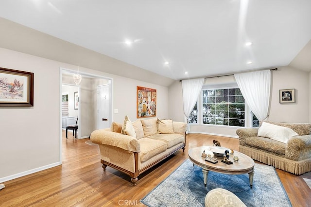 living room with light wood finished floors, recessed lighting, baseboards, and vaulted ceiling