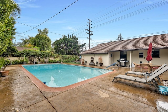 view of swimming pool featuring a patio area, a fenced in pool, and grilling area