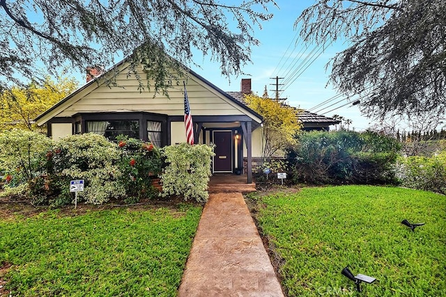 view of front of property with a front lawn and a chimney