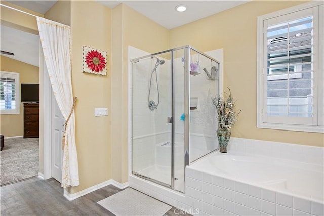 full bathroom with a garden tub, wood finished floors, a stall shower, and baseboards