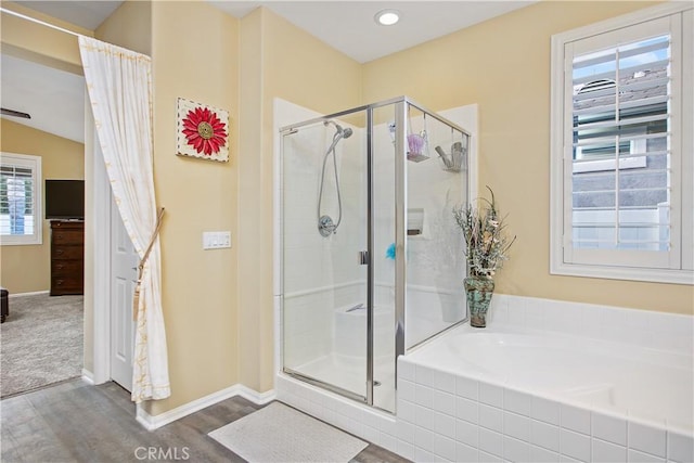 full bath with a shower stall, baseboards, a garden tub, and wood finished floors