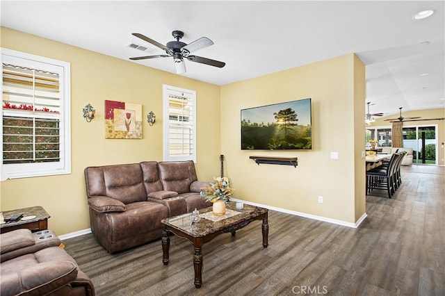 living room with visible vents, wood finished floors, baseboards, and ceiling fan