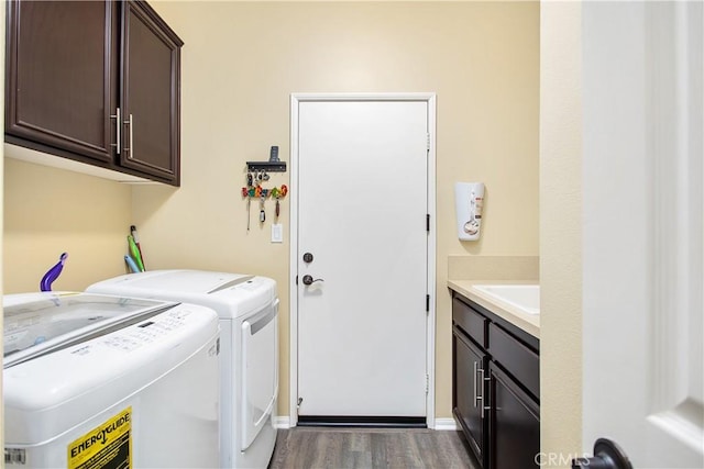 laundry area featuring separate washer and dryer, cabinet space, dark wood-style flooring, and a sink