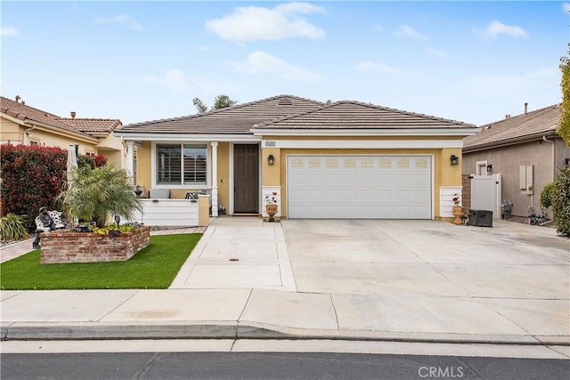 ranch-style house with a tile roof, an attached garage, driveway, and stucco siding