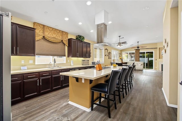 kitchen with a center island, wood finished floors, light countertops, and a ceiling fan