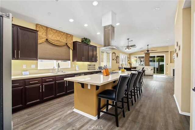 30283 Moon Star Cir, Menifee, CA 92584 - kitchen with a kitchen island, wood finished floors, a ceiling fan, light countertops, and a kitchen breakfast bar