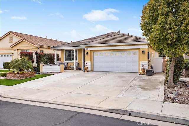 ranch-style house featuring a garage, driveway, fence, and a tile roof