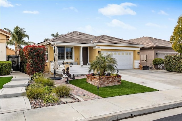 view of front facade with stucco siding, driveway, a tile roof, and an attached garage