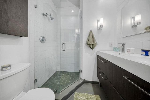 full bath featuring vanity, toilet, baseboards, and a stall shower