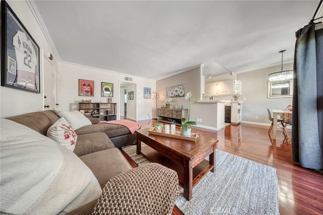 living room featuring crown molding, wood finished floors, and baseboards