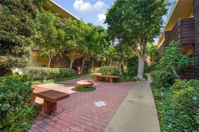 view of community with a patio, a fire pit, and fence