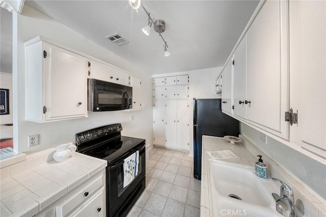 kitchen featuring tile countertops, visible vents, a sink, black appliances, and white cabinetry