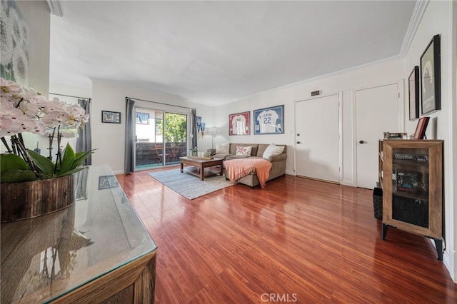 living area featuring wood finished floors and ornamental molding