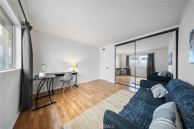 living area featuring visible vents, baseboards, and wood finished floors