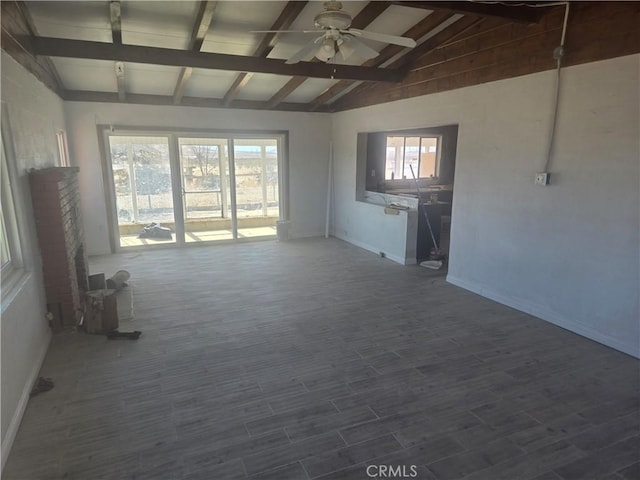 interior space featuring dark wood finished floors, vaulted ceiling with beams, and ceiling fan