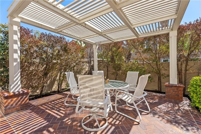 view of patio featuring outdoor dining area, a pergola, and fence