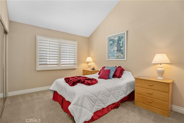 bedroom featuring lofted ceiling, carpet flooring, baseboards, and a closet