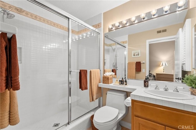 full bathroom with visible vents, toilet, a stall shower, and vanity