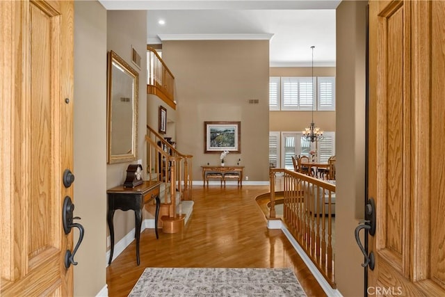 foyer entrance with visible vents, baseboards, stairs, wood finished floors, and a notable chandelier