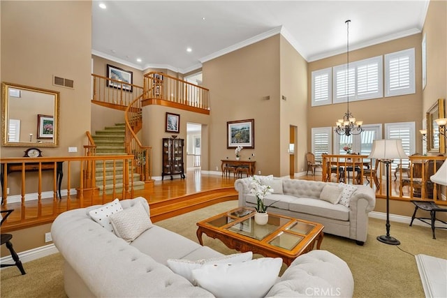 living room featuring visible vents, ornamental molding, stairway, baseboards, and a chandelier