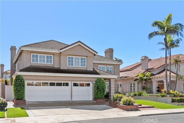 traditional-style home featuring stucco siding, a garage, driveway, and a tiled roof