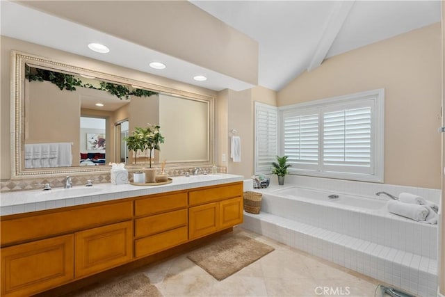 ensuite bathroom featuring double vanity, a bath, a sink, and vaulted ceiling