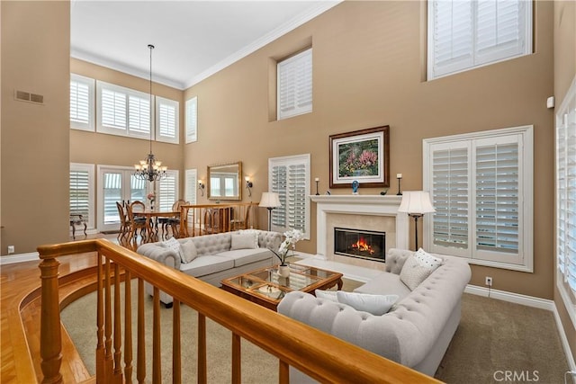 living area with a fireplace, crown molding, baseboards, and visible vents