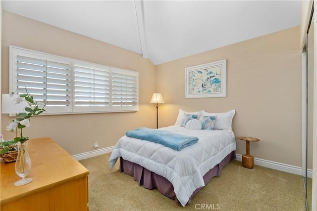 bedroom with baseboards, lofted ceiling, and carpet