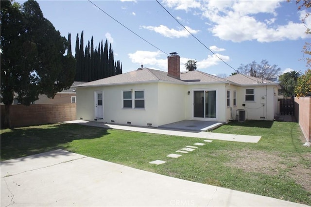 back of property featuring a lawn, stucco siding, a fenced backyard, crawl space, and a patio