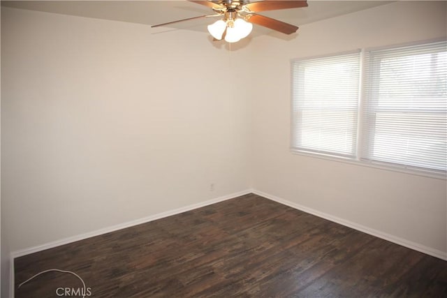 unfurnished room with ceiling fan, baseboards, and dark wood finished floors