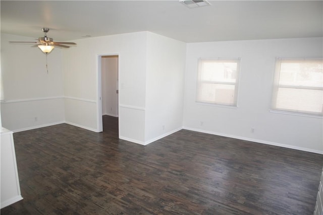 spare room featuring visible vents, a ceiling fan, baseboards, and wood finished floors