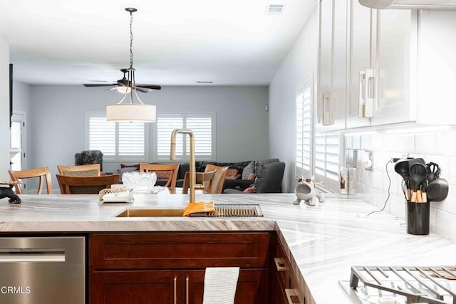 kitchen with visible vents, a sink, light countertops, dishwasher, and backsplash