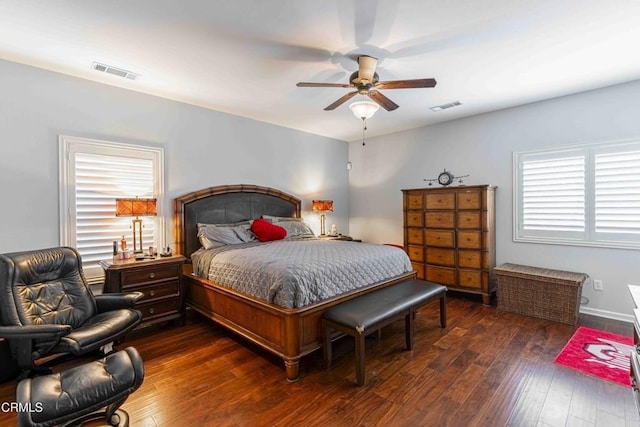 bedroom featuring visible vents, a ceiling fan, baseboards, and dark wood-style flooring