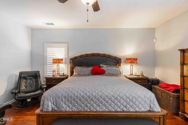 bedroom with visible vents, baseboards, wood finished floors, and a ceiling fan