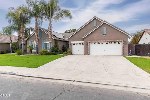 traditional home with stucco siding, driveway, a front lawn, fence, and a garage